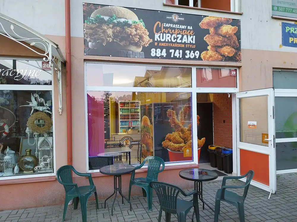 Wejście do Crispy Chicken Bistro ze stolikami przed lokalem